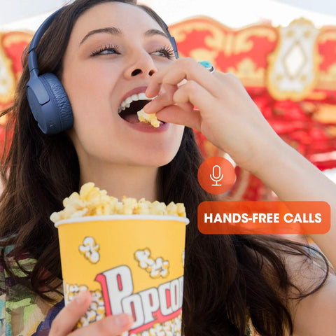 Person wearing Wireless Bluetooth Cans With Up To 40 Hours Battery, Built-In Microphone For Calls while eating popcorn.