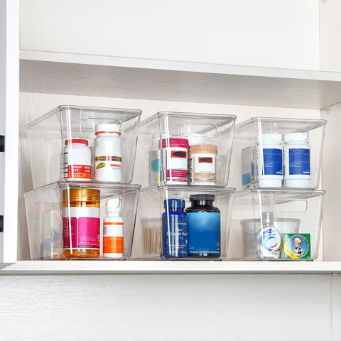 Six Pack Clear Stackable Storage Bins With Secure Lids And Sturdy Handles Medium Size housing various bottles on a shelf.