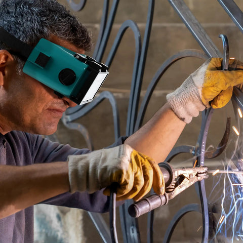 Rock Solid Auto Darkening Welding Goggles With Flip Up Lens Solar Powered For Instant Shade Change and Hassle Free MIG TIG Plus Gas Cutting Coverage You Will Appreciate Back At The Shop worn by welder using MIG technique.