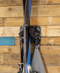 Rugged Black Gravity Lock Ski And Snowboard Wall Mount Rack Keeps Your Tip Rocker And Tail Lock Tight Premium Slip Resistant Grip for skis on wooden wall.