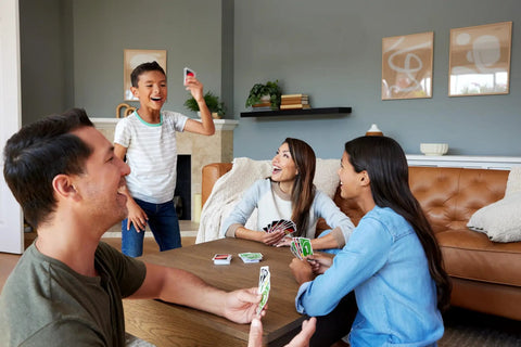 Group of four playing Total Kick Back Uno Card Game For Weekend Hangouts, enjoying fun in a cozy living room.