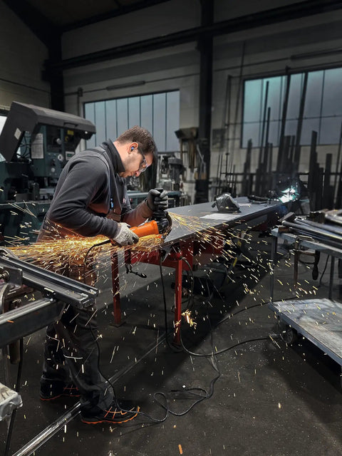 Top Shelf 1400 Watt Angle Grinder Packs Knock Tough 125mm Cutting Muscle in action, creating sparks during metal work.