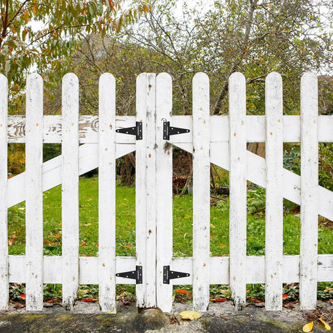 White wooden fence with Ten Pack 4 Inch T Strap Tee Hinge Heavy Duty Black Barn Door Hinges for garden doors, outdoor installation view.