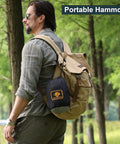 Man in forest with backpack carrying Camping Hammock With Mosquito Net Ready To Roll For Outdoors Ultralight And Easy Setup