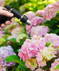 Top Shelf Inline Garden Hose Carbon Water Filter in use to enhance plant health, spraying pink hydrangeas for optimal growth.