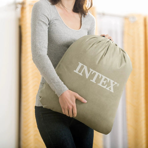 Super Thick Twin Air Mattress With Built In Pump And Roll Up Travel Bag, gray travel bag held by a person.