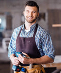 Person holding a drill inside a workshop.