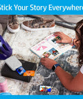 Person using Pocket Sized Photo Printer For Instant Two By Three Inch Sticky Back Photos From Your Phone On The Go Luna Pearl Edition, next to scrapbook.