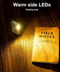 Angel Eyes E8 Keychain Flashlight 700 Lumens USB C Rechargeable EDC Light illuminating notebook on wood table