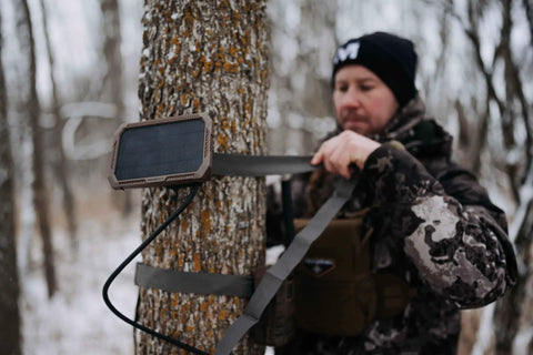 Kickass Rugged Solar Power Panel With Hella Durable Weather Resistant Housing And Fast Charge Usb Port Paired With Ten Foot Insulated Cables mounted on tree.