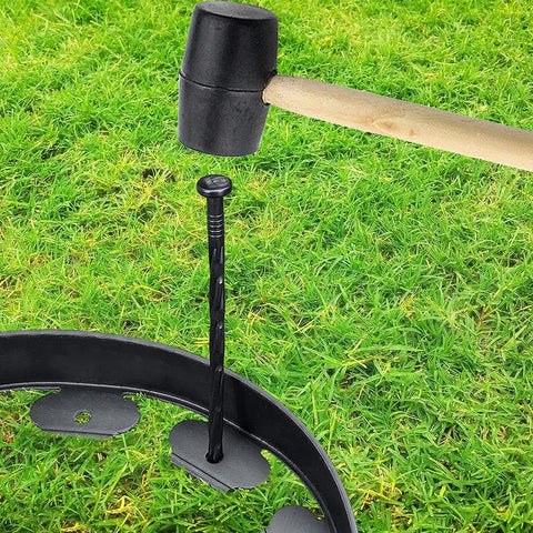 Spiral Landscape Anchoring Spikes 8 Inch Set For Lawn Edging Tough As Nails Durable Plastic Stakes in use with rubber mallet on grass