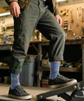 Man in workshop wearing Three Pack Mechanical Engineering Socks Gift Set For Gearhead Men And Techy Dads with tool prints size 7-13.