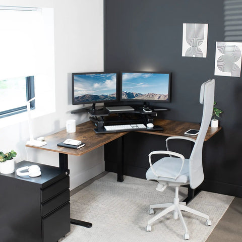 43 Inch Corner Electric Height Adjustable Desk Riser For Dual Monitors set up in a modern home office with dual monitors