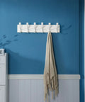 Wooden Wall Coat Rack With Six Hooks White Finish Modern Space Saving Wall Hanger for coats on blue wall with beige scarf hanging