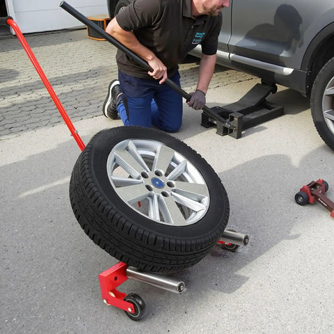 Man using Heavy Duty Adjustable Tire Wheel Dolly Full Size Cart Rock Solid 660 Lbs Capacity for tire removal in garage.