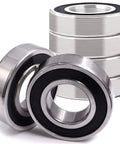 Two C3 spindle bearings with thermal expansion design, next to stack of four bearings, suitable for heavy-duty trailers and farm equipment.