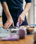 Top Tier Loop Handle Rotary Cutter For Heavy Duty Fabric And Vinyl Crafting Precision Ground Steel Blade in use with fabric.
