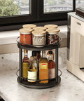 No Fuss Dual Tier Lazy Susan Turntable Gliding On Slick Ball Bearings, Compact Black Spice Rack Organizer For Kitchen Counters And Cabinets, 360 Degree Spinner Tray with spice jars and oils on display.