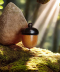 Hella Slick Screw Open Miniature Black Ebony Acorn Curios Set Of Two With Hidden Antique Bronze Pinecones For Super Dope Fall Harvest Woodland Decor on mossy surface.