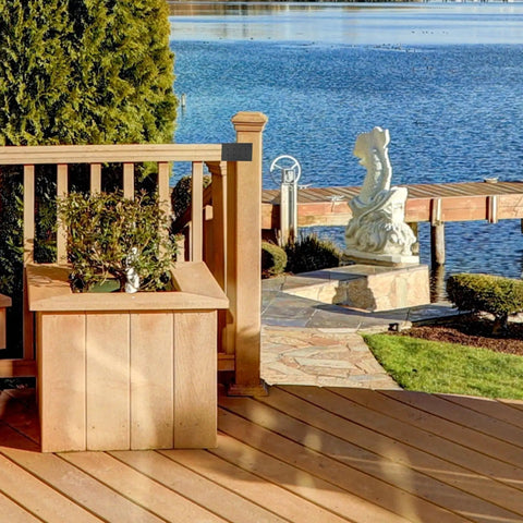 Wooden deck with railing and planters near a lake, featuring heavy duty pergola brackets kit for 4x4 wood posts with included screws.