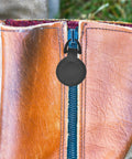 Close-up of Five Piece Set Of Badass Black Alloy Zipper Pull Replacement Tabs for Heavy Duty Backpacks on leather zipper.