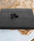 Custom Cut Black Packing Foam Insert Pad Rock Solid Cushion Block Super Useful For Shipping Moving Gear Around Without A Hitc on a table.