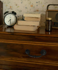 Slick And Dang Durable Drop Bail Cabinet Pulls With Oil Rubbed Bronze Finish on a wooden drawer with books and a clock.