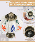 Top Shelf Vintage Hand Painted Ceramic Pumpkin Drawer Knobs With Bold Red Floral Branch Design For Badass Home Decor Renovations And Slick Cabinet Upgrades Including Hardware Kit close-up of ceramic knob with bronze base and red floral design.