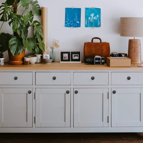 White cabinet with 60 Pack Matte Black Zinc Kitchen Cabinet Knobs And Drawer Pulls For Dressers installed on doors and drawers.