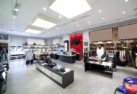 Modern retail store interior showcasing apparel and accessories with bright illumination from overhead lights.
