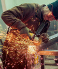 Worker using angle grinder with Heavy Duty Secondary Side Handle For Angle Grinders featuring Dead Tough Build and Hella Solid Non Slip Grip.