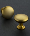 Premium Zinc Cabinet Knobs Featuring A Killer Gold Finish And Fresh Euro Style Vibe Built Different For Long Lasting Performance A Straight Up Quality 30 Pack Furniture Hardware Refresh, two brushed gold knobs on dark surface.