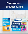 Various Fixodent adhesive products displayed, including Fixodent Extra Hold Powder and tubes with multiple formulas in a bathroom setting.