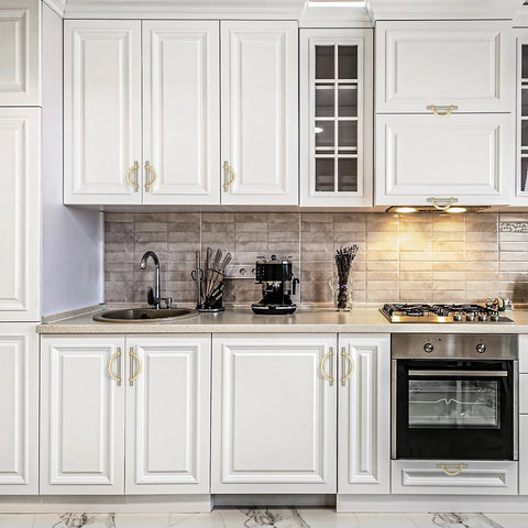 Brushed Brass And Brushed Nickel Cabinet Pulls 5 Inch Center To Center Curved Handles installed on white kitchen cupboards.