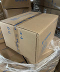 Close-up of a brown cardboard box labeled Grizzle, stacked on other boxes in a warehouse setting.