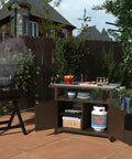 Outdoor Wood Grill Prep Table With Stainless Steel Top Waterproof Cover Dark Brown Finish Solid Wood Construction No Plastic Open Shelf For Quick Access Storage Heavy Duty Outdoor Kitchen Station in a backyard setting next to a grill.
