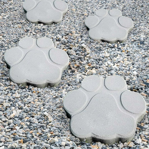 Two Big Paw Print Stepping Stone Molds Set 16 Inch And 13 Inch Concrete Textured Plastic Craft Molds placed on a gravel pathway