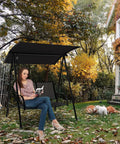 Woman sitting on a Two Person Porch Swing With Adjustable Canopy, Comfortable Fabric Seat And Heavy Duty Steel Frame in a garden