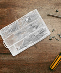 32 Piece Stainless Steel Toggle Bolts And Drywall Anchors Kit with wing nuts on a wooden surface next to screws and screwdriver
