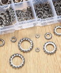 Top-down view of stainless steel external-tooth star lock washers in assorted sizes beside a clear plastic organizer tray.