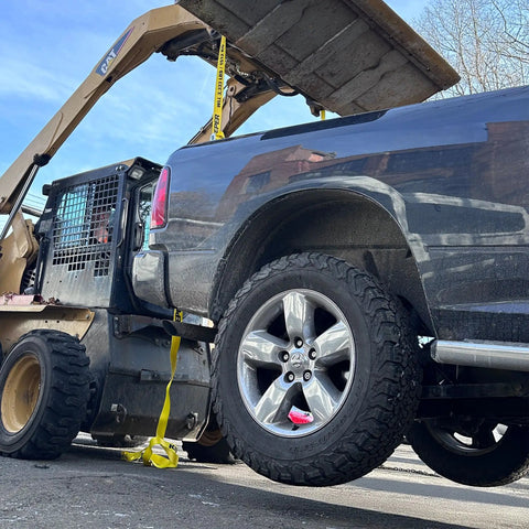 Truck with Two Pack Truck Bed Anchor Kit securing cargo using ratchet straps, visible anchor on tailgate, rugged polyester webbing.