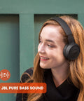 Person wearing black Wireless Bluetooth Cans With Up To 40 Hours Battery, Built-In Microphone For Calls, Foldable And Ultra Comfortable.
