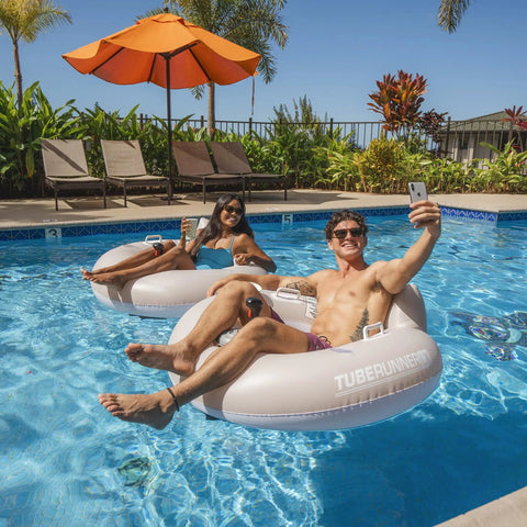 Adults relaxing in pool with Motorized Pool Tube Float For Adults Pro 3.0 With 66W Motor Joystick Steering Phone Holder And Cup Holder Blue Finish Lets You Glide Turn And Cruise Across The Water All Day.
