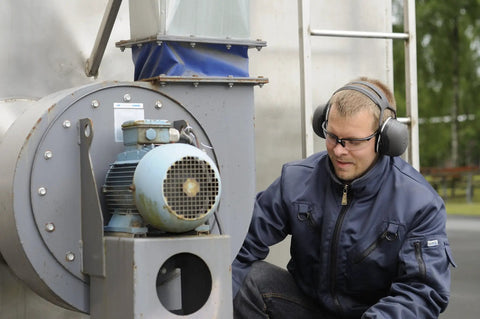 Top Shelf Heavy Duty Earmuffs Industrial Grade With Dielectric Wire Headband And Tilt Earcups worn by a worker at a motor.