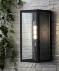 Top Shelf One Light Outdoor Wall Lantern In Sleek Black And Gold Blend Optimized For Zero Fuss Wiring And Packed With Efficient Led Bulbs on a textured wall.