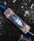 Weatherproof Extension Cord Protector with clear housing on wet surface, sealing 12-gauge blue cord, IP55 and IK09 rated