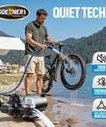 Man using Zero Hassle 12V RV Water Pump With Smart Pressure Switch to wash bike by lake outdoors.