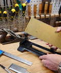 Person placing Double Sided Diamond Sharpening Stone With Base DuoSharp 10 Inch Bench Stone in workshop setting