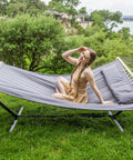 Two Person Hammock With Stand Heavy Duty Portable Hammock Supports Up To 475 Lbs Fade Resistant Quilted Polyester For Outdoor Camping And Backyard Chill Sessions Dark Grey with woman relaxing on it