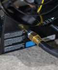 Close-up of 125,000 BTU Forced Air Propane Space Heater connections with 10 ft hose and regulator on concrete surface.